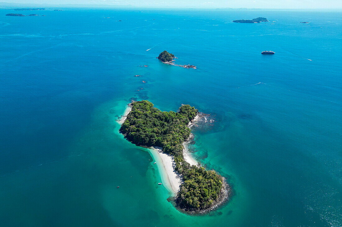 Aerial view of pristine beaches on island with expedition cruise ship World Voyager (nicko cruises) in distance, Isla Gómez, near Isla Parida, Paridas Islands, Gulf of Chiriqui, Panama, Central America