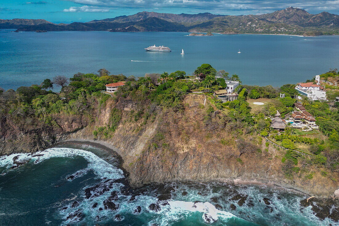 Luftaufnahme von Villen auf Landzunge mit Expeditionskreuzfahrtschiff World Voyager (nicko cruises) in Bucht, Playa Flamingo, Guanacaste, Costa Rica, Mittelamerika