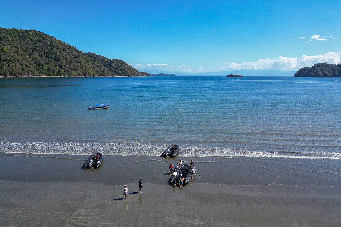 Aerial view of a Zodiac inflatable boat landing from expedition cruise ship World Voyager (nicko cruises) on the beach of Curú Wildlife Refuge, Curu, near Tambor, Nicoya Peninsula, Puntarenas, Costa Rica, Central America
