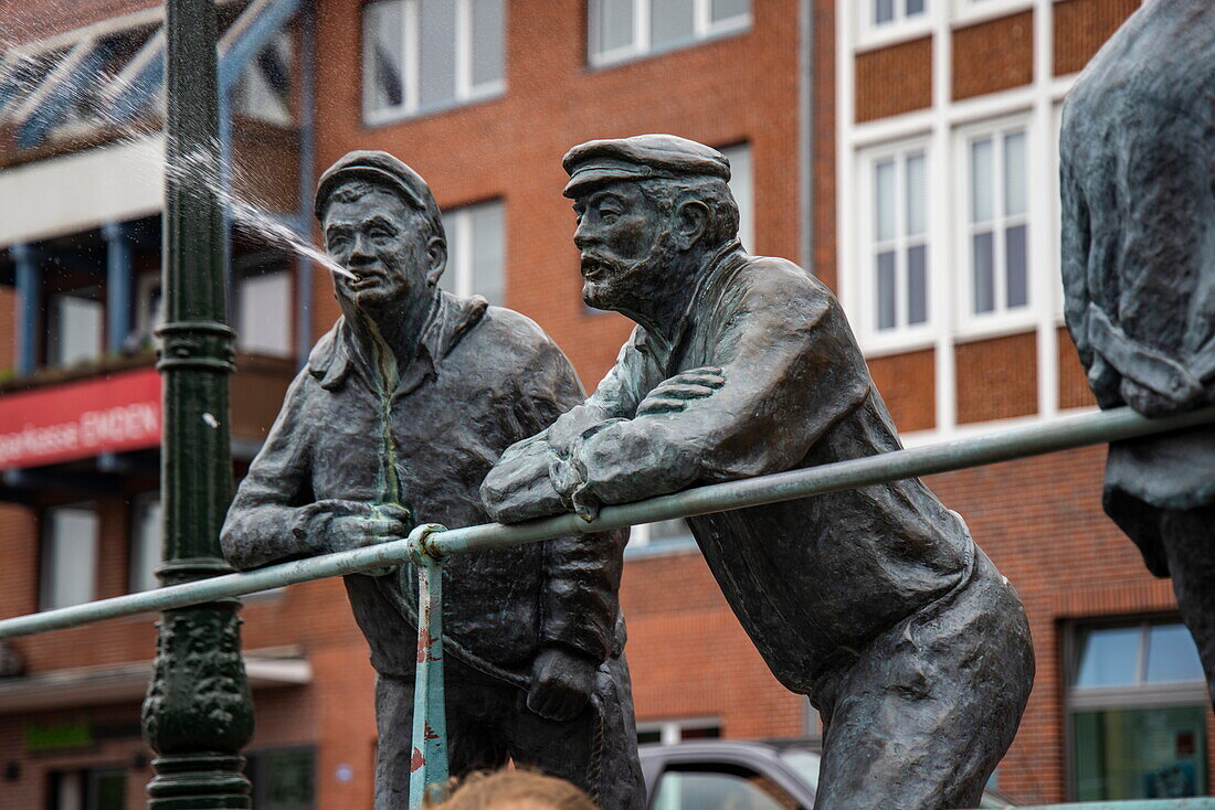 Delft spitter sculpture of men with sporadic surprise element in the form of water fountains, Emden, Lower Saxony, Germany, Europe