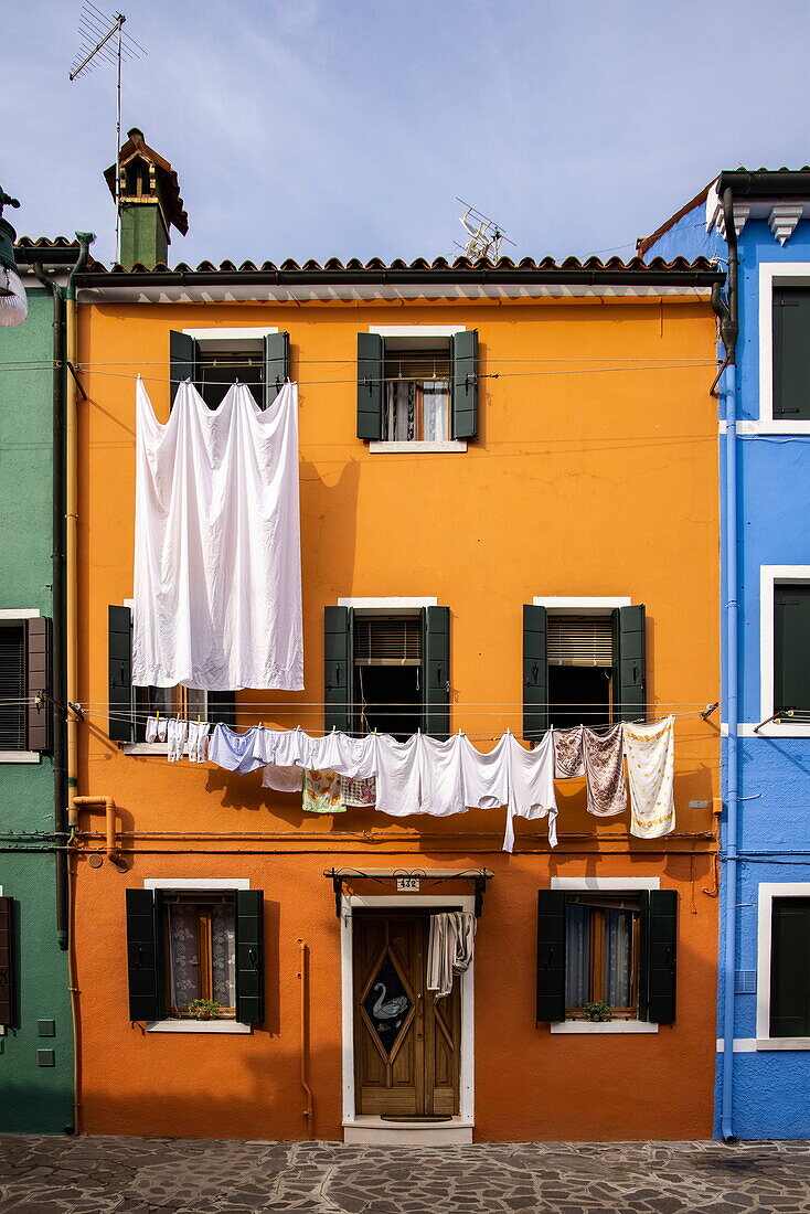 Wäsche hängt zum Trocknen außerhalb eines bunten Hauses, Burano, Venedig, Italien, Europa