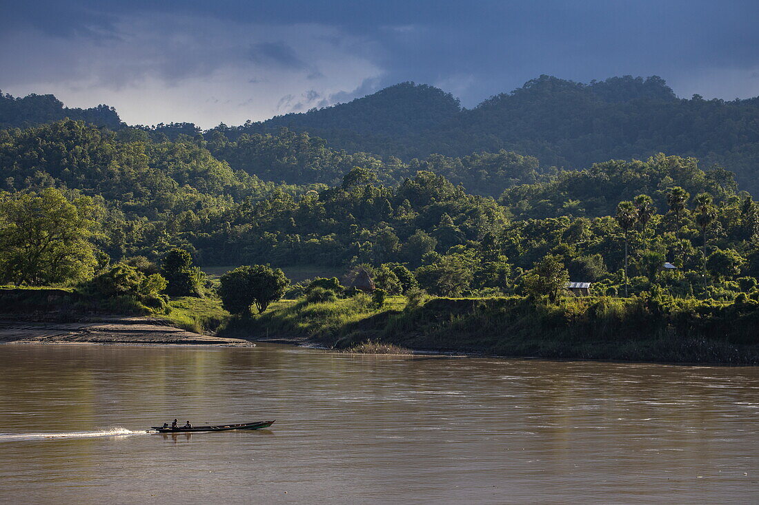 Longtail-Boot auf dem Fluss Chindwin, üppige Felder und Berge dahinter, in der Nähe von Kalewa, Region Sagaing, Myanmar, Asien