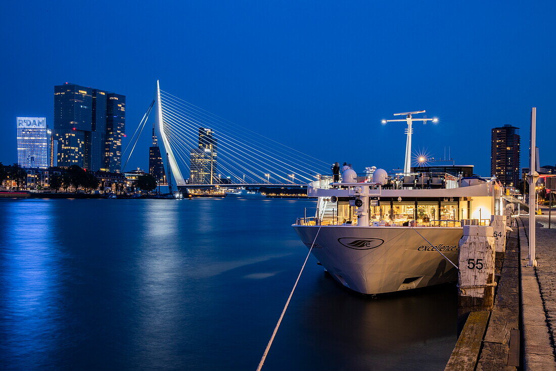 Flusskreuzfahrtschiff Excellence Countess mit Erasmusbrücke (Erasmusbrug) über Nieuwe Maas und Skyline bei Nacht, Rotterdam, Südholland, Niederlande, Europa