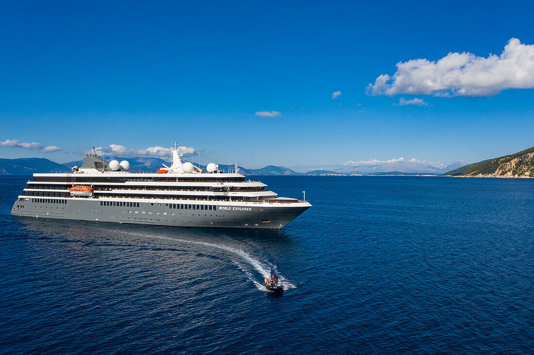 Aerial view of expedition cruise ship World Explorer (Nicko Cruises) with passengers enjoying excursion by Zodiac inflatable boat, Fiskardo, Kefalonia, Ionian Islands, Greece, Europe