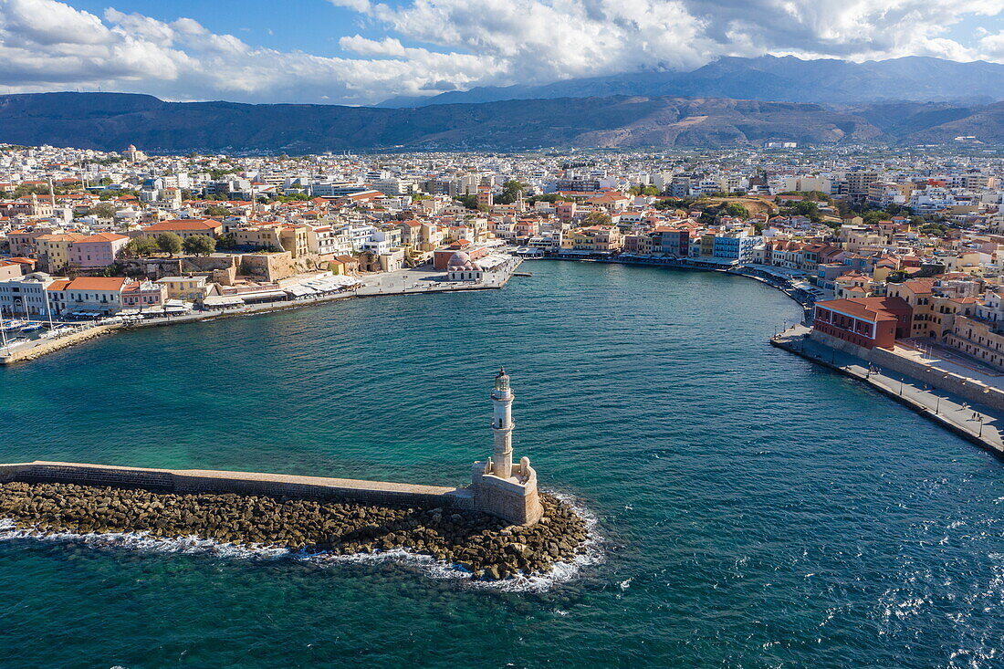 Aerial view of the lighthouse on the breakwater with Venetian Harbor and Chania Old Town behind, Chania, Crete, Greece, Europe