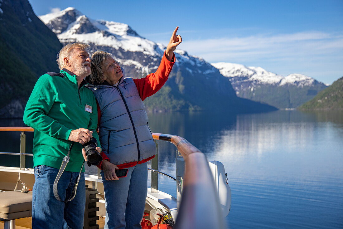 Paar am Geländer von Expeditionskreuzfahrtschiff World Voyager (nicko cruises) im Sunnylvsfjorden, in der Nähe von Stranda, Møre og Romsdal, Norwegen, Europa