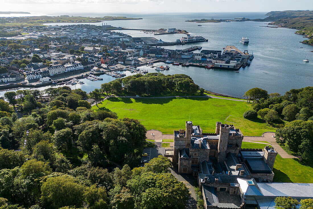Aerial view of Lews Castle with city and expedition cruise ship World Voyager (nicko cruises) at the pier, Stornoway, Lewis and Harris, Outer Hebrides, Scotland, United Kingdom, Europe