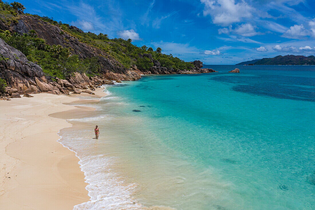 Aerial view of a young woman walking on Anse St Jose beach, Curieuse island, Seychelles, Indian Ocean