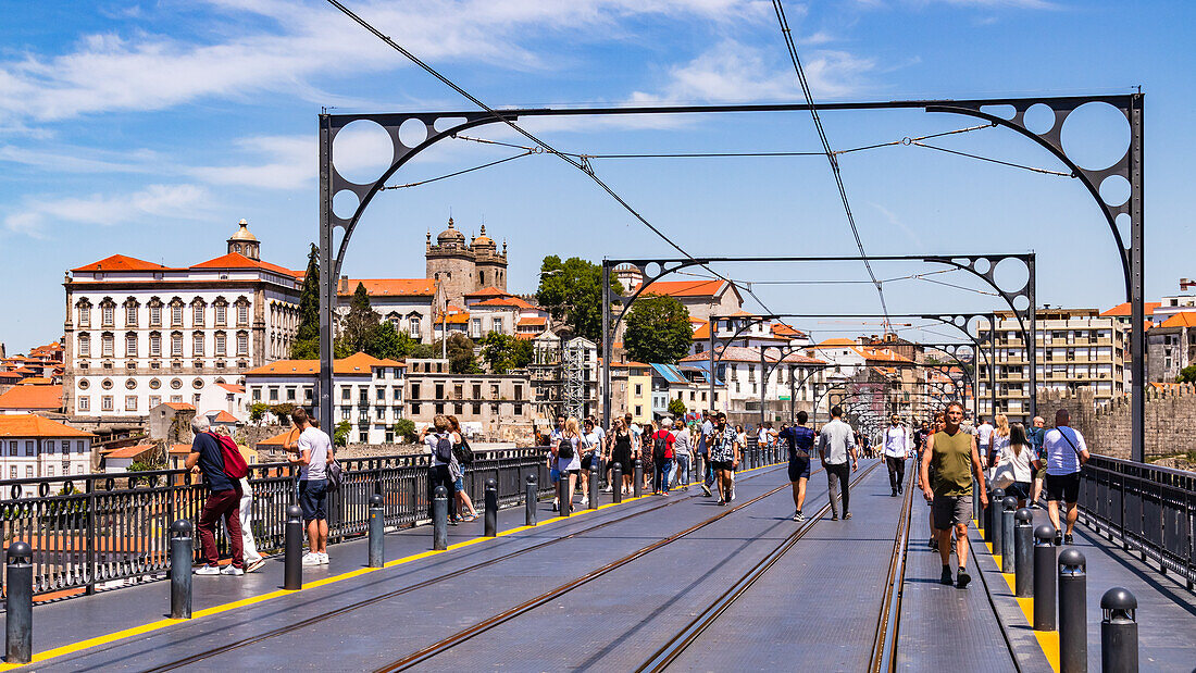 The busy pedestrian and metro truss arch bridge Ponte Luíz I overlooking the Cathedral and Bishop's Palace of Porto, Portugal