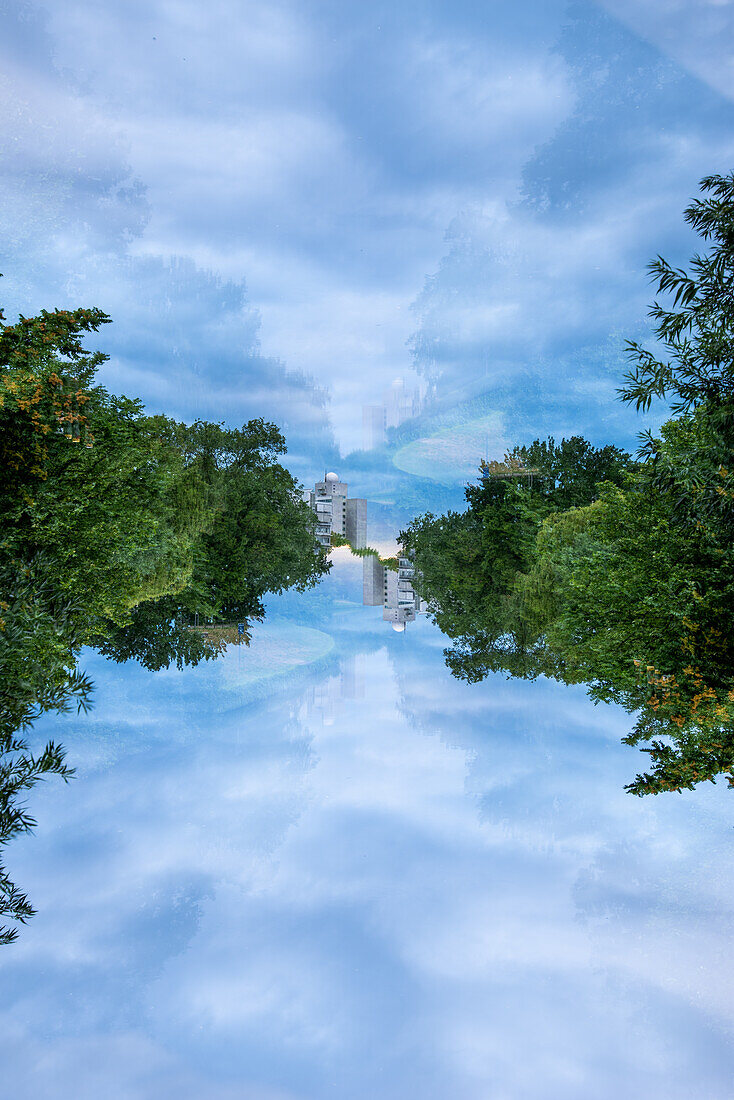 Double exposure view of the Spree river lined by leafy trees.