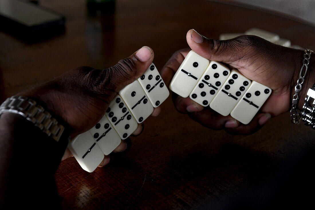 Hände halten Dominosteine während eines Spiels in Bar, Saint David, Grenada, Karibik