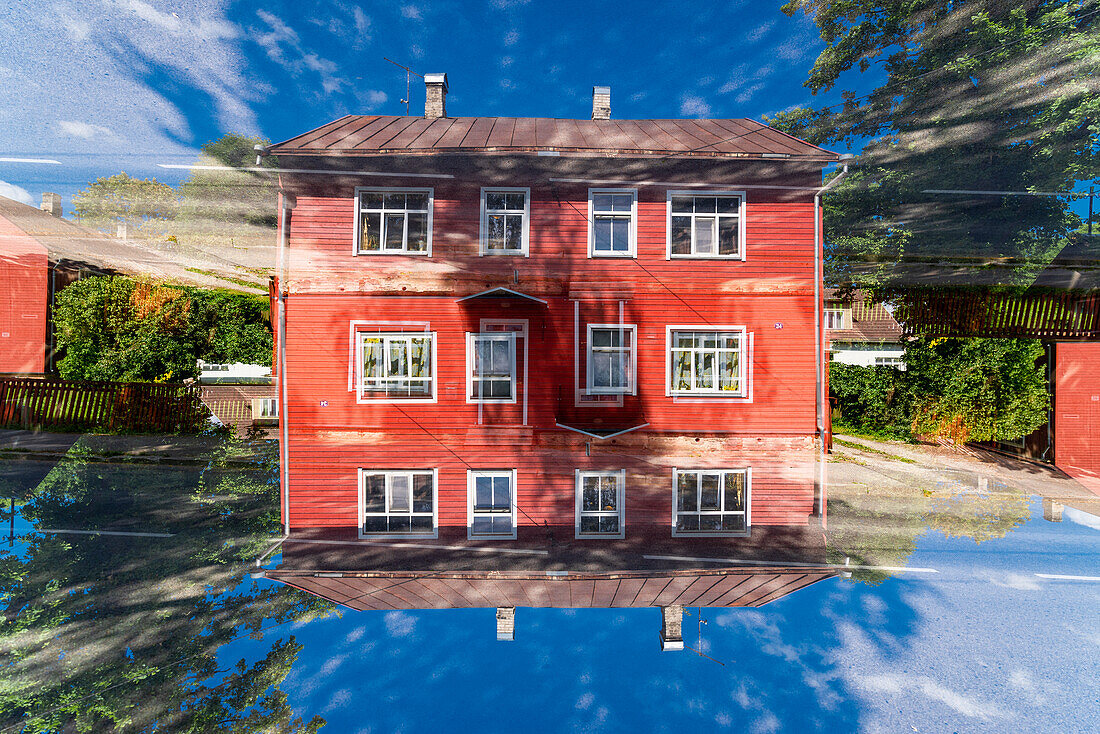 Doppelbelichtung eines roten Wohngebäudes aus Holz in Tartu, Estland.