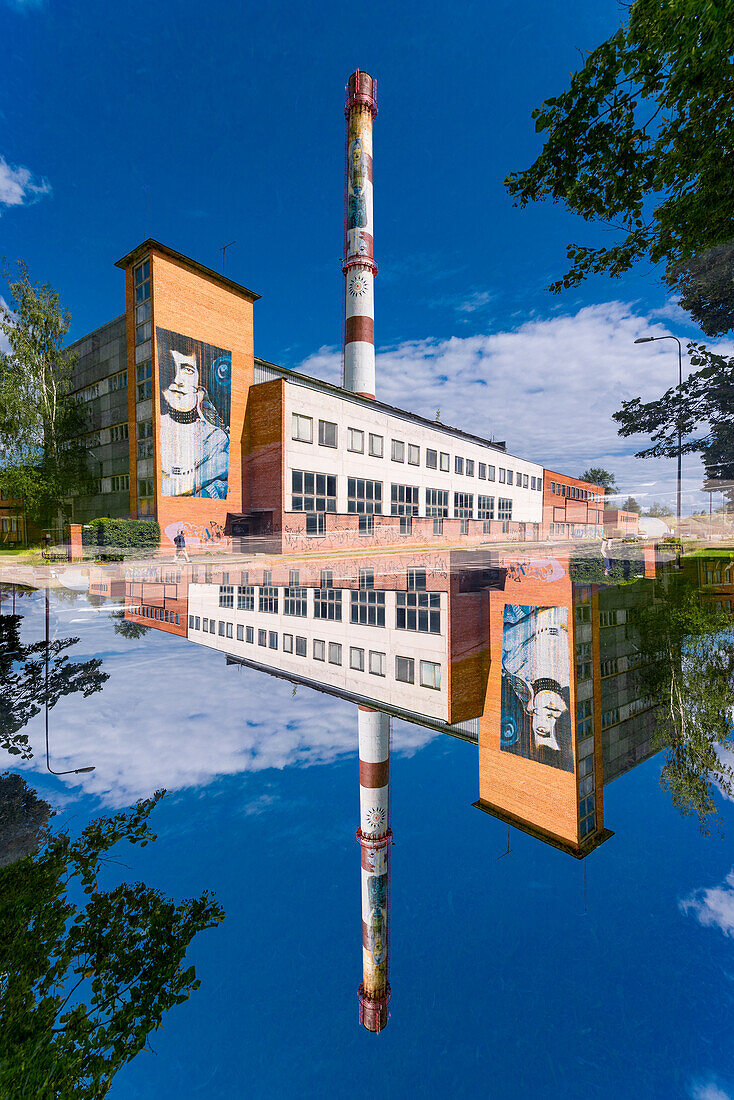 Doppelbelichtung einer heruntergekommenen Fabrik in grüner Umgebung in Tartu, Estland