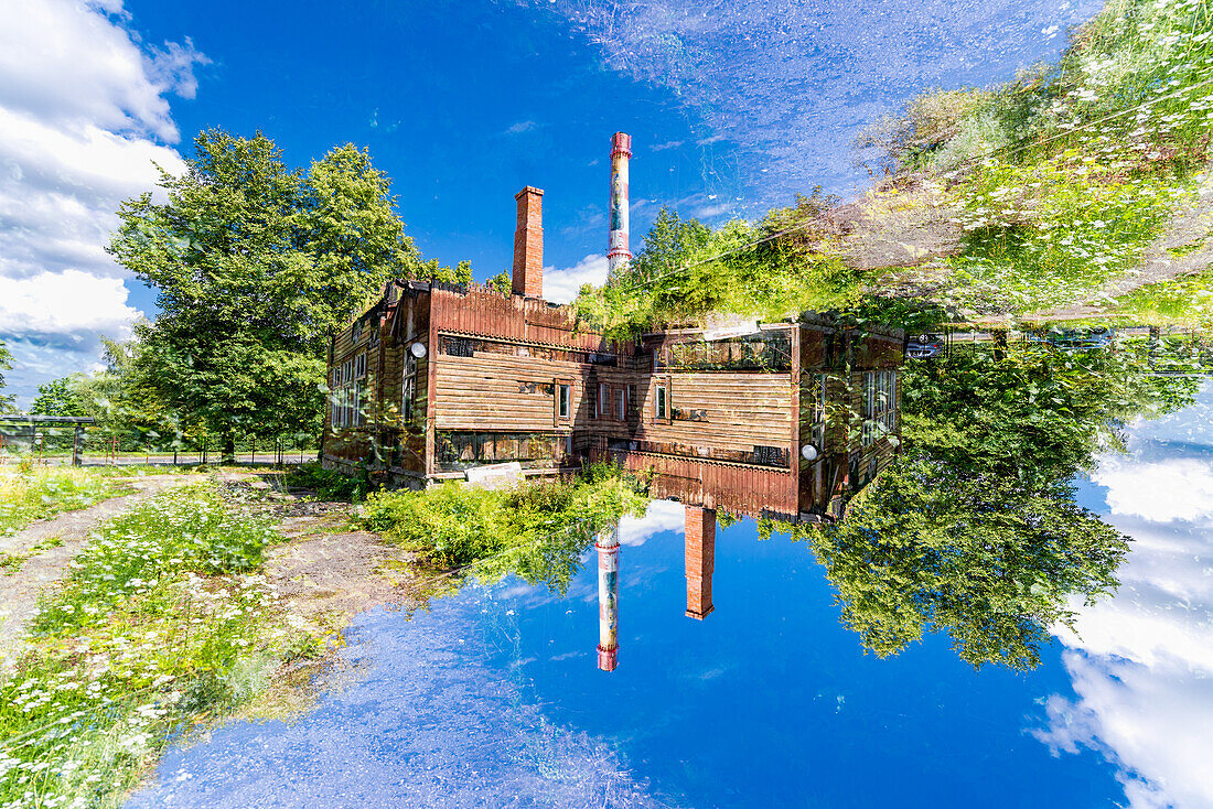 Doppelbelichtung einer heruntergekommenen Fabrik in grüner Umgebung in Tartu, Estland