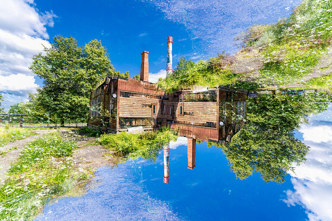 Double exposure of a worn down factory in a green setting in Tartu, Estonia