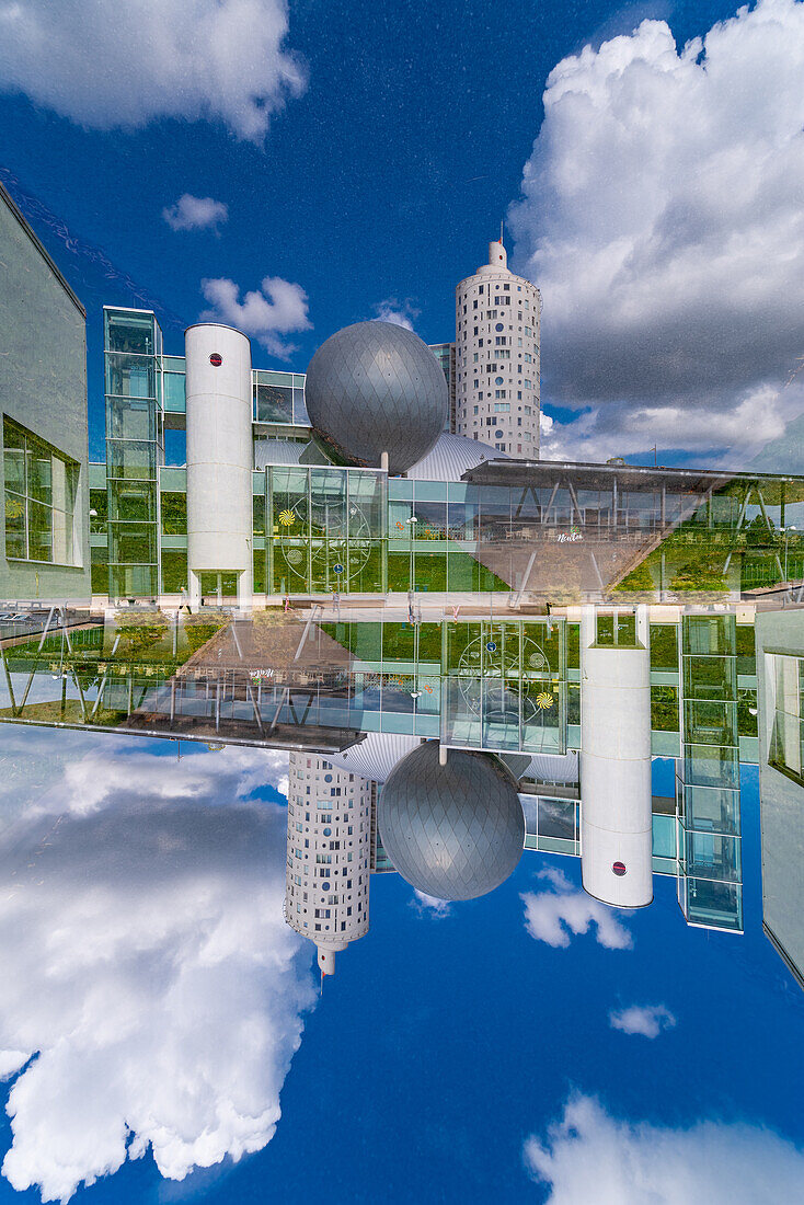 Doppelbelichtung eines säulenförmigen modernen Gebäudes neben einem Globus in Tartu, Estland
