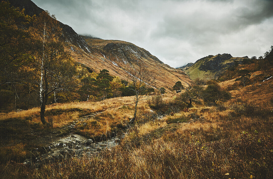 Berge von Glen Coe mit Fluss, Bach. Landschaft im Herbst, Highlands, Schottland, Vereinigtes Königreich