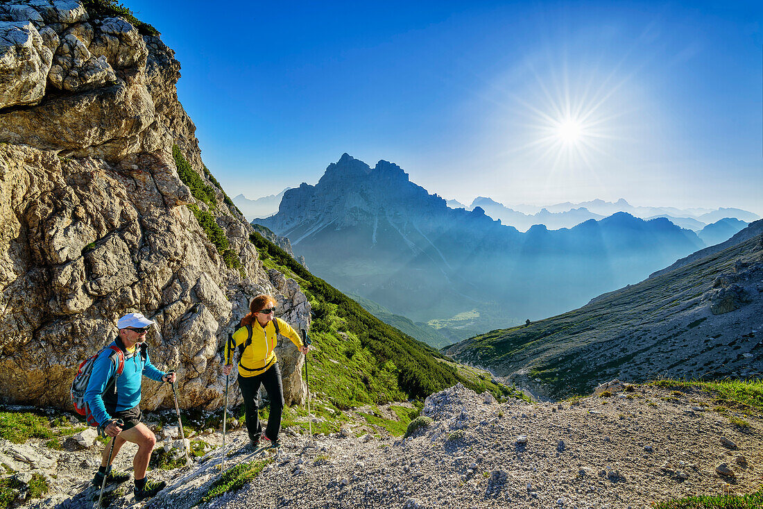Man and woman hiking on a hiking trail on the ridge, Cima di Pramper in the background, Belluneser Höhenweg, Dolomites, Veneto, Venetia, Italy