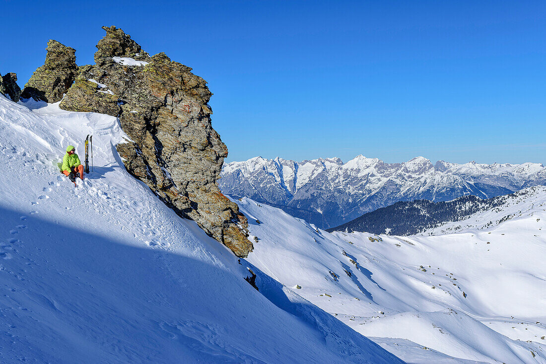 Frau auf Skitour zum Rosskopf sitzt im Schnee und macht Pause, Rosskopf, Hochfügen, Tuxer Alpen, Tirol, Österreich