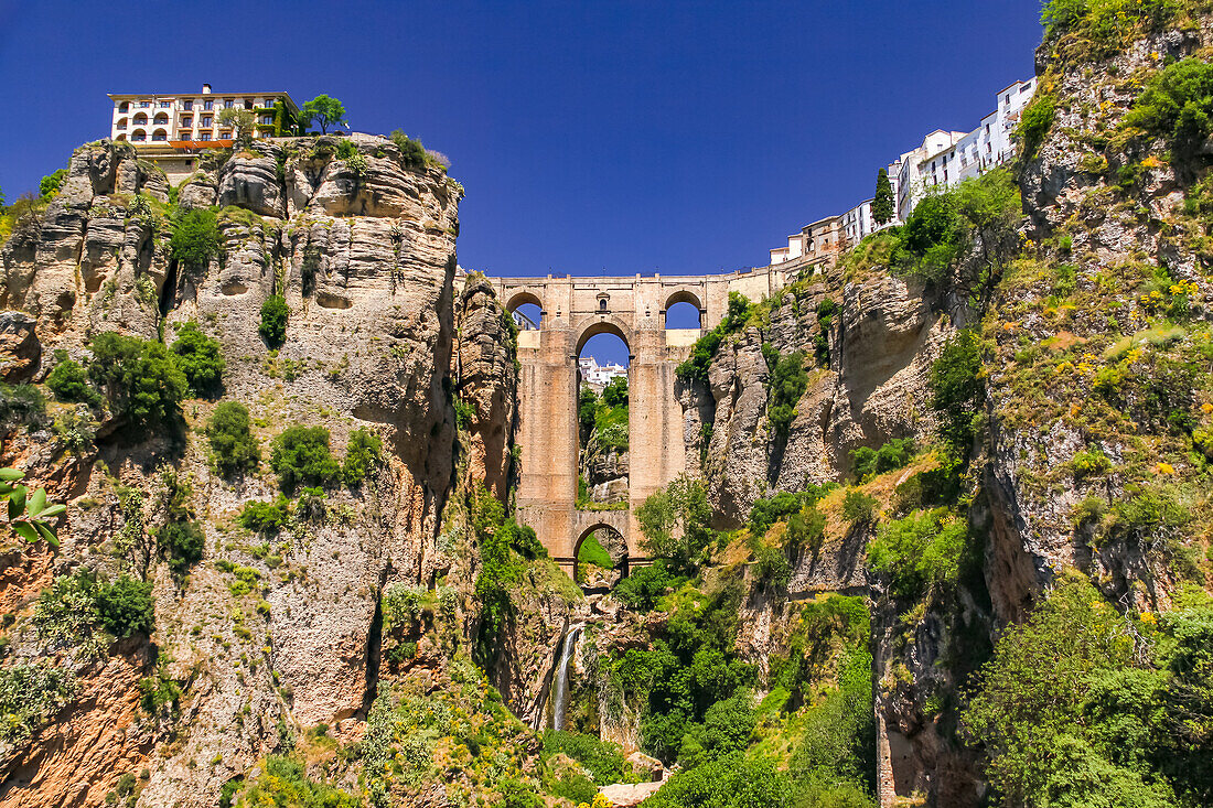 Die malerische Stadt Ronda mit der Puente Nuevo die spektakulär die Schlucht in der Stadt überbrückt, Andalusien, Spanien