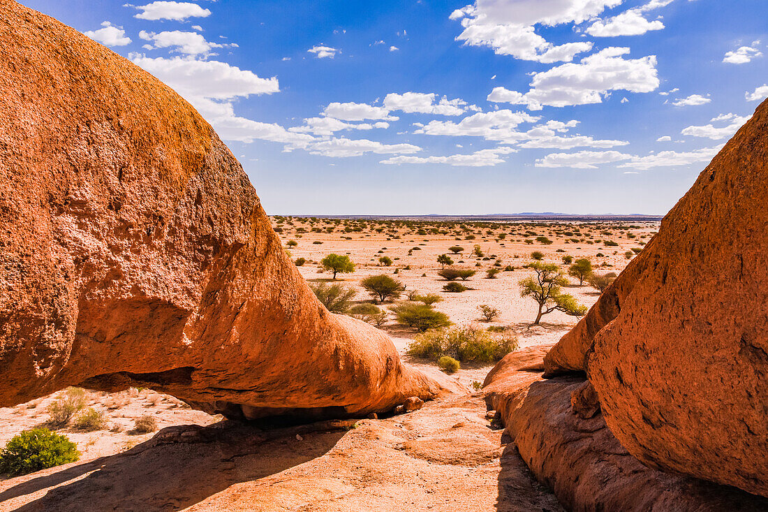 Ein natürlicher Felsbogen aus Granit bei der Spitzkoppe vor der umliegenden Ebene der Savanne in Namibia, Afrika