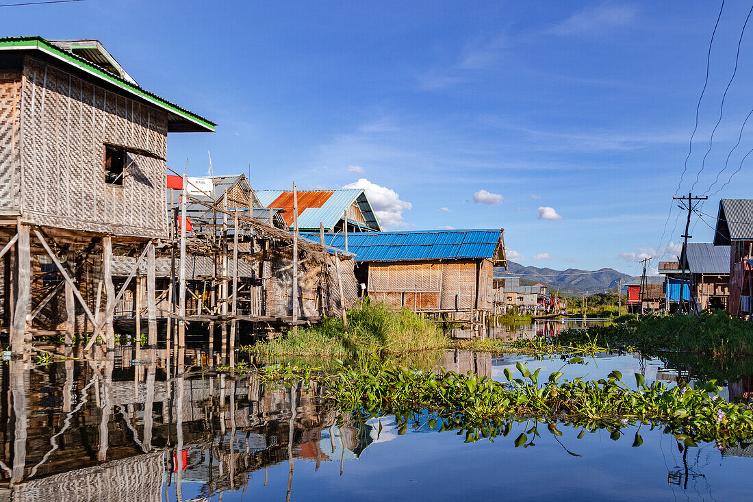 Mehrere traditionelle Holzhäuser auf Stelzen im idyllischen Inle-See im burmesischen Nang Pang, Myanmar, Asien