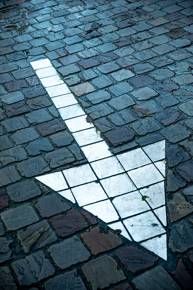 An arrow laid in cobblestones