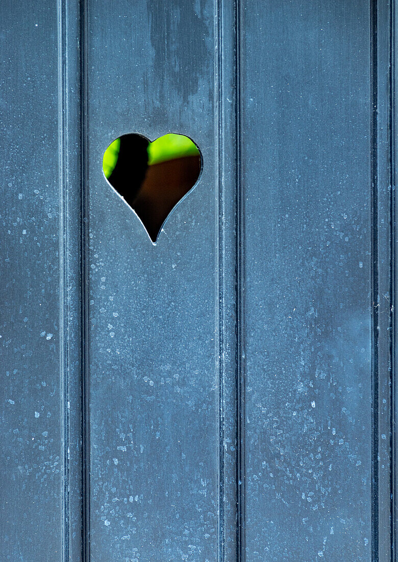 Wooden door with heart shaped cutout.