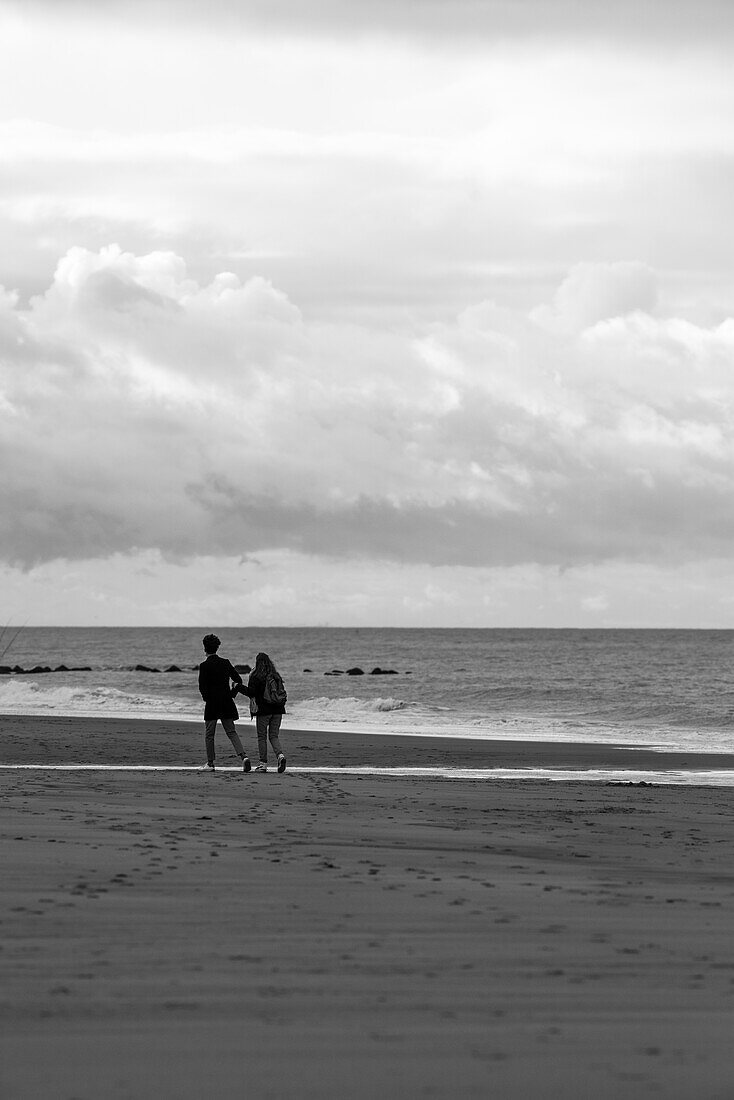Couple walking on the beach in Ostend, Belgium.