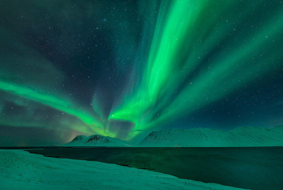 Aurora Borealis over a fjord in Iceland, Iceland.