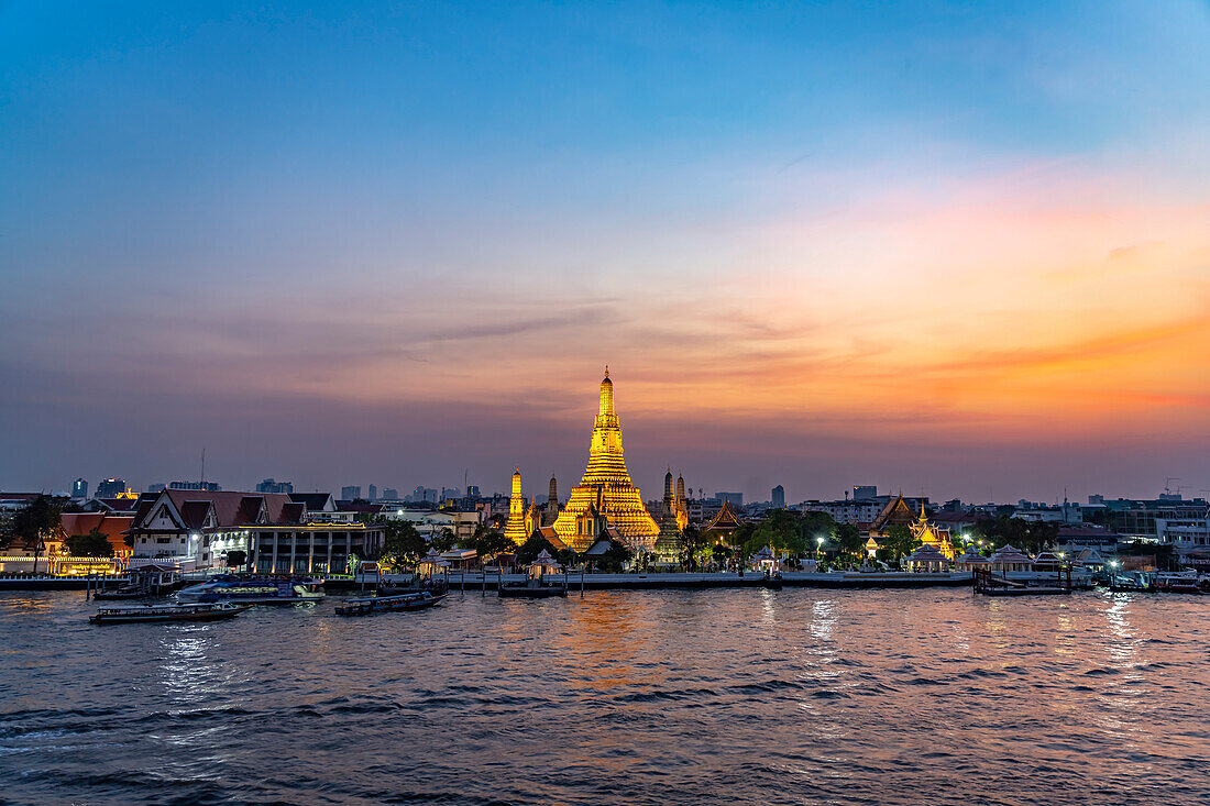 Der buddhistische Tempel Wat Arun oder Tempel der Morgenröte und der Fluss Chao-Phraya  in der Abenddämmerung, Bangkok, Thailand, Asien 