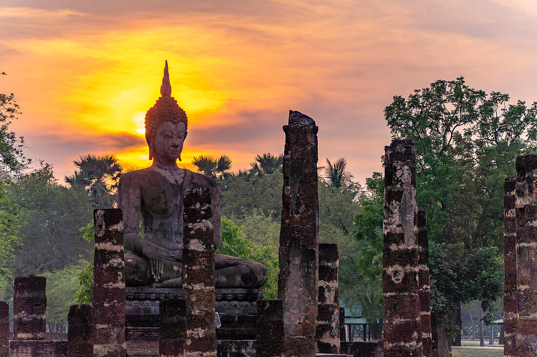 Sonnenuntergang an einer Buddha Statue des Tempel Wat Mahathat, UNESCO Welterbe Geschichtspark Sukhothai, Thailand, Asien