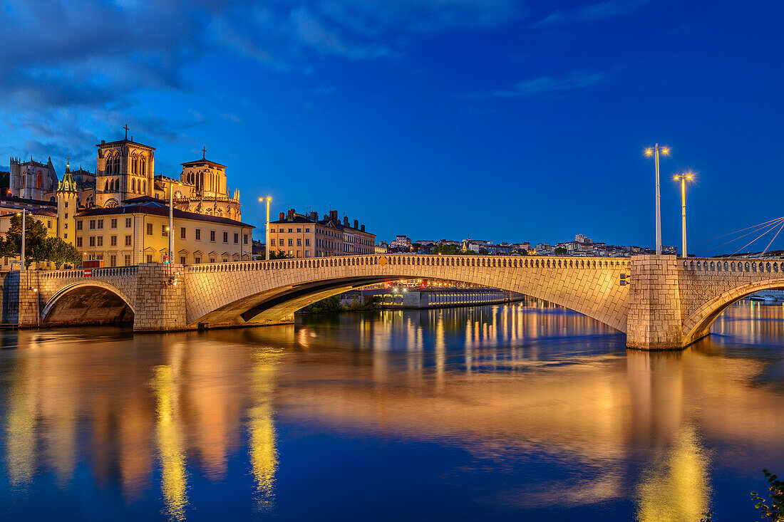 Illuminated Cathédrale Saint-Jean church with Pont Bonaparte bridge over the Saone river, Lyon, Auvergne-Rhône-Alpes, France