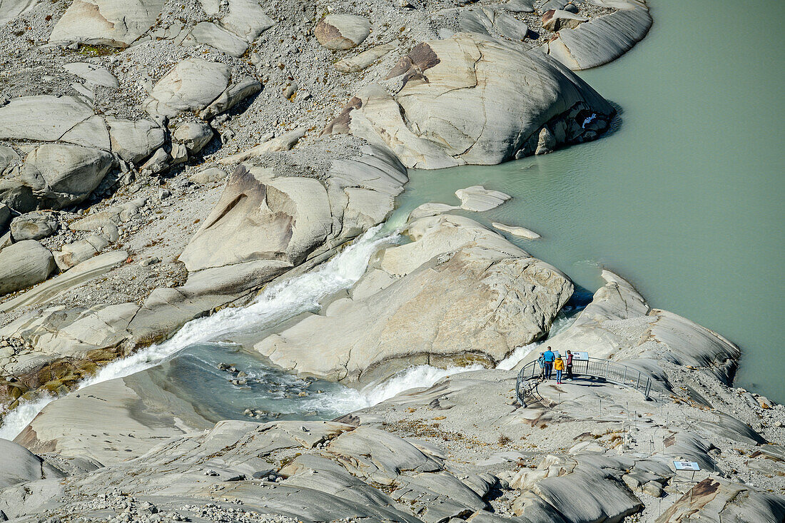 Several people are standing at a vantage point above the source of the Rhone, Uri Alps, Valais, Switzerland