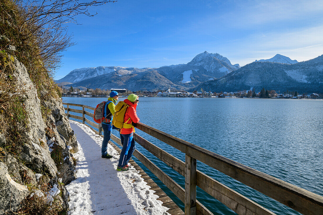 Mann und Frau wandern am Bürglsteig mit Strobl im Hintergrund, Bürglsteig, Strobl, Wolfgangsee, Salzkammergut, Salzkammergutberge, Salzburg, Österreich