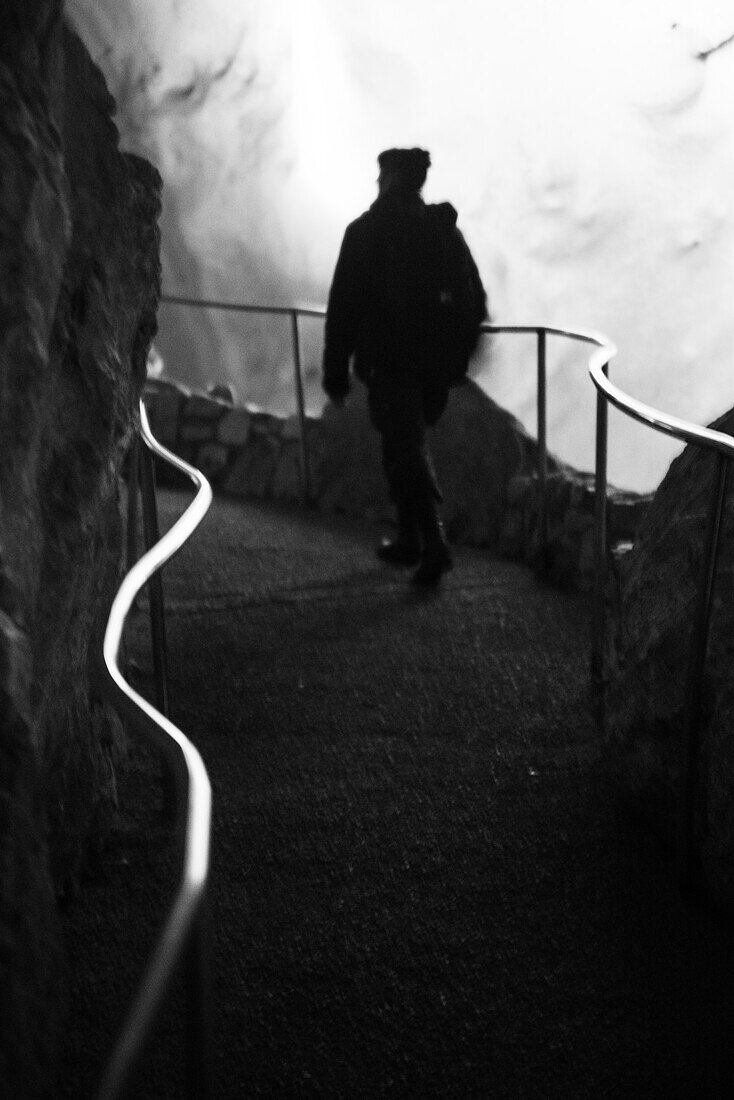 Woman walking down Carlsbad Cavern caves.