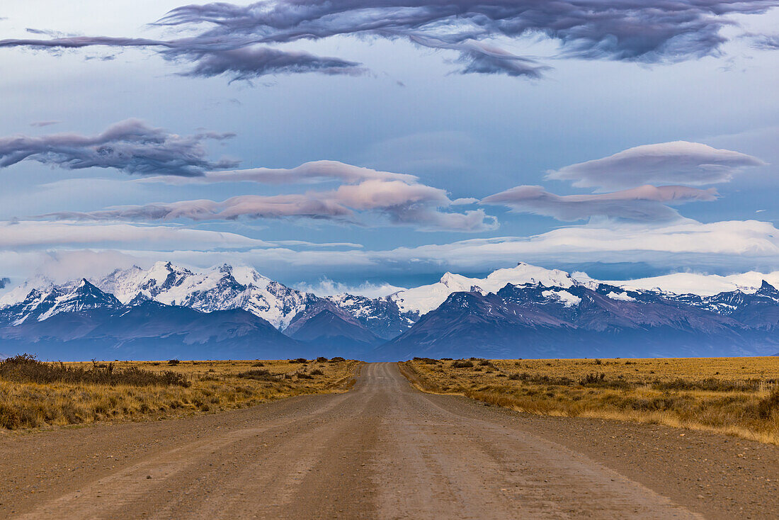 Panoramablick auf die Cordillera de los Andes vor Sonnenaufgang entlang einer Schotterpiste mit spektakulären Wolken, Argentinien, Patagonien, Südamerika