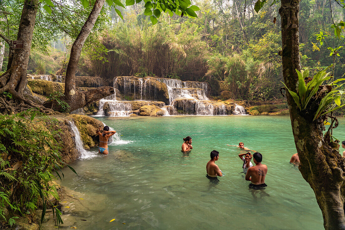 Tourists bathe in Kuang Si Waterfall near Luang Prabang, Laos, Asia