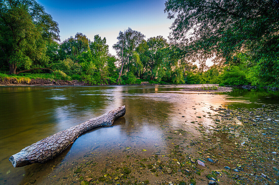 Langzeitbelichtung am steinigen Ufer vom Fluss Saale im Sommer bei Sonnenuntergang und blauem Himmel, Jena, Thüringen, Deutschland