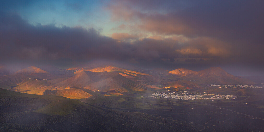 Panorama bei Sonnenaufgang vom Montana de Guardilama zum Weinanbaugebiet La Geria, dahinter die Orte Uga und Yaiza, Lanzarote, Kanarische Inseln, Spanien, Europa