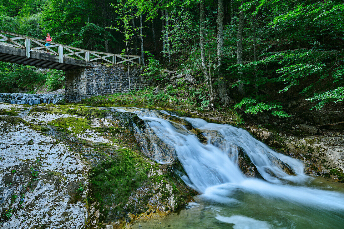 Frau beim Wandern steht auf Brücke über den Rio Arazas, Ordesatal, Nationalpark Ordesa y Monte Perdido, Ordesa, Huesca, Aragon, UNESCO Welterbe Monte Perdido, Pyrenäen, Spanien