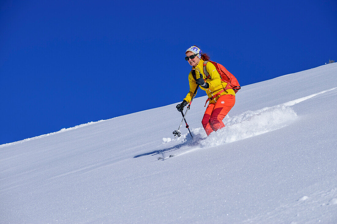 Frau bei Tiefschneeabfahrt vom Wiedersberger Horn, Wiedersberger Horn, Kitzbüheler Alpen, Tirol, Österreich