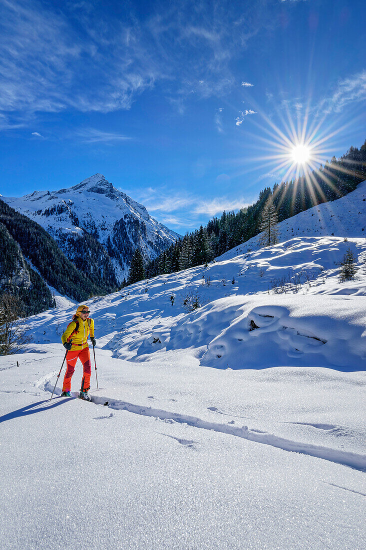 Frau auf Skitour steigt zum Roller auf, Wechselspitze im Hintergrund, Gerlos, Zillertaler Alpen, Tirol, Österreich