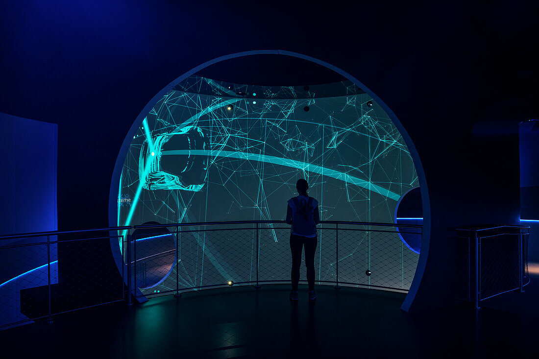 Woman looks at visualizations in a pavilion in Autostadt in Wolfsburg, Lower Saxony, Germany, Europe
