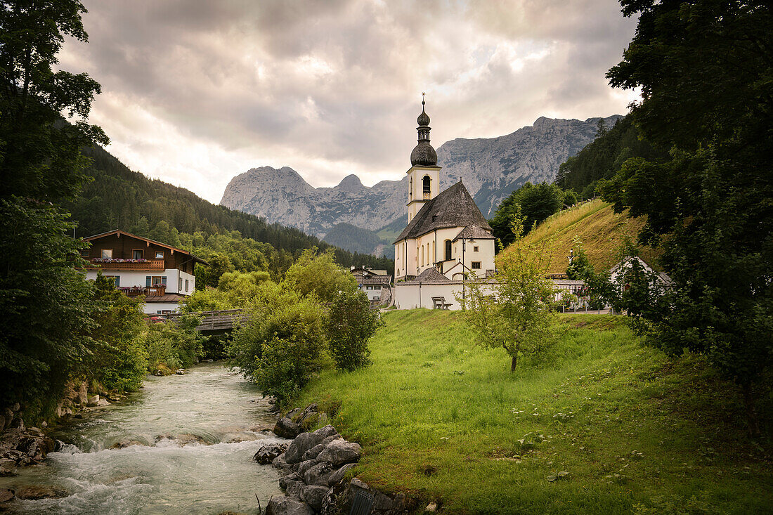 Blick über Fluss Ramsauer Ache hin zur Pfarrkirche St. Sebastian, Ramsau, Nationalpark Berchtesgaden, Bayern, Deutschland, Europa