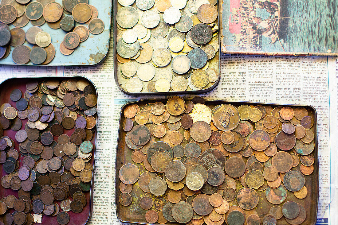 Pune, Indien, alte indische Artefakte, Münzen auf alter Zeitung