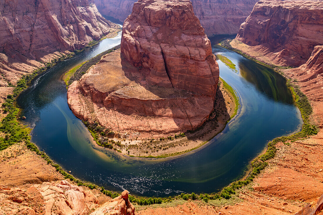 Colorful view of the Horseshoe Bent meander on the blue Colorado River at sunset against the light, Page, Arizona, USA