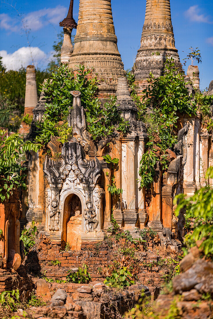 The many colorful and overgrown stupas of the In-Dein Pagoda Forest on Inle Lake in Myanmar, Asia