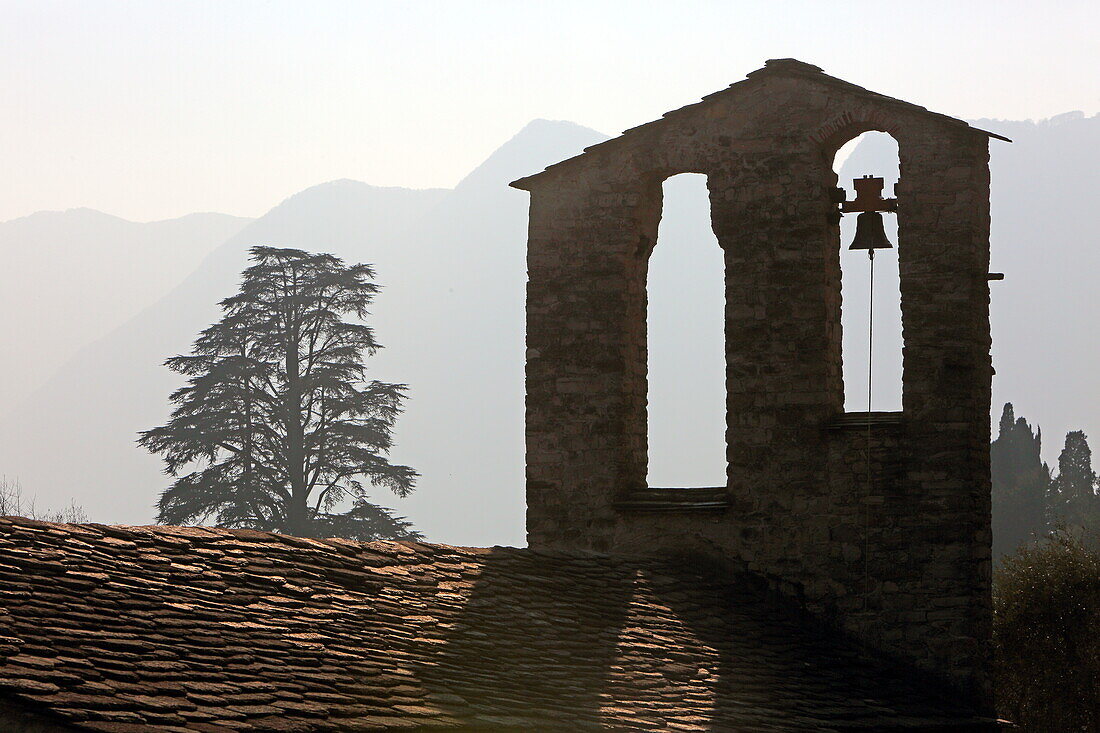 Roof and bell tower of an ancient church in the village of Ossuccio, situated on the western shore of Lake Como, Lombardy, Italy