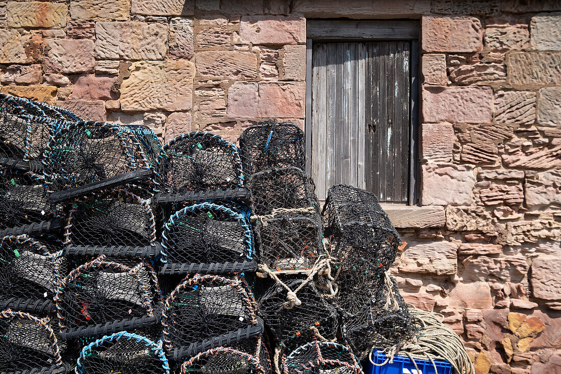 View of fishing paraphernalia, lobster fishing baskets in North Berwick harbour, East Lothian, Scotland, United Kingdom